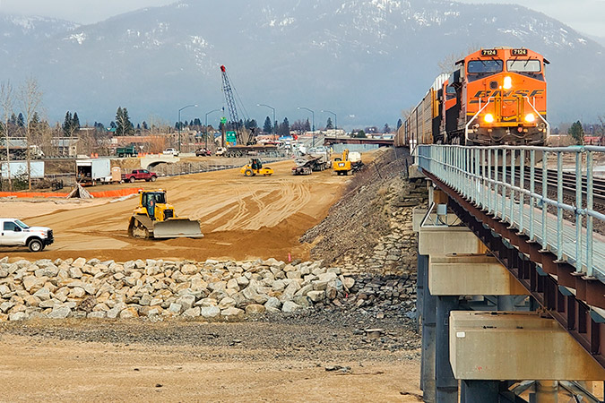 A BNSF train approaches the north end of the existing bridge at Sandpoint, with construction of the new bridge adjacent. Photo by Jeremy Kruskie, BNSF