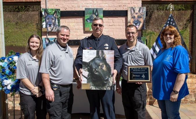 Schaffer at the WRTP K-9 memorial holding a photo of Faust. 
